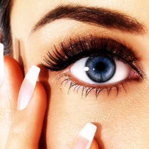 Details of beauty. French manicured nails and eye with ceremonial makeup
